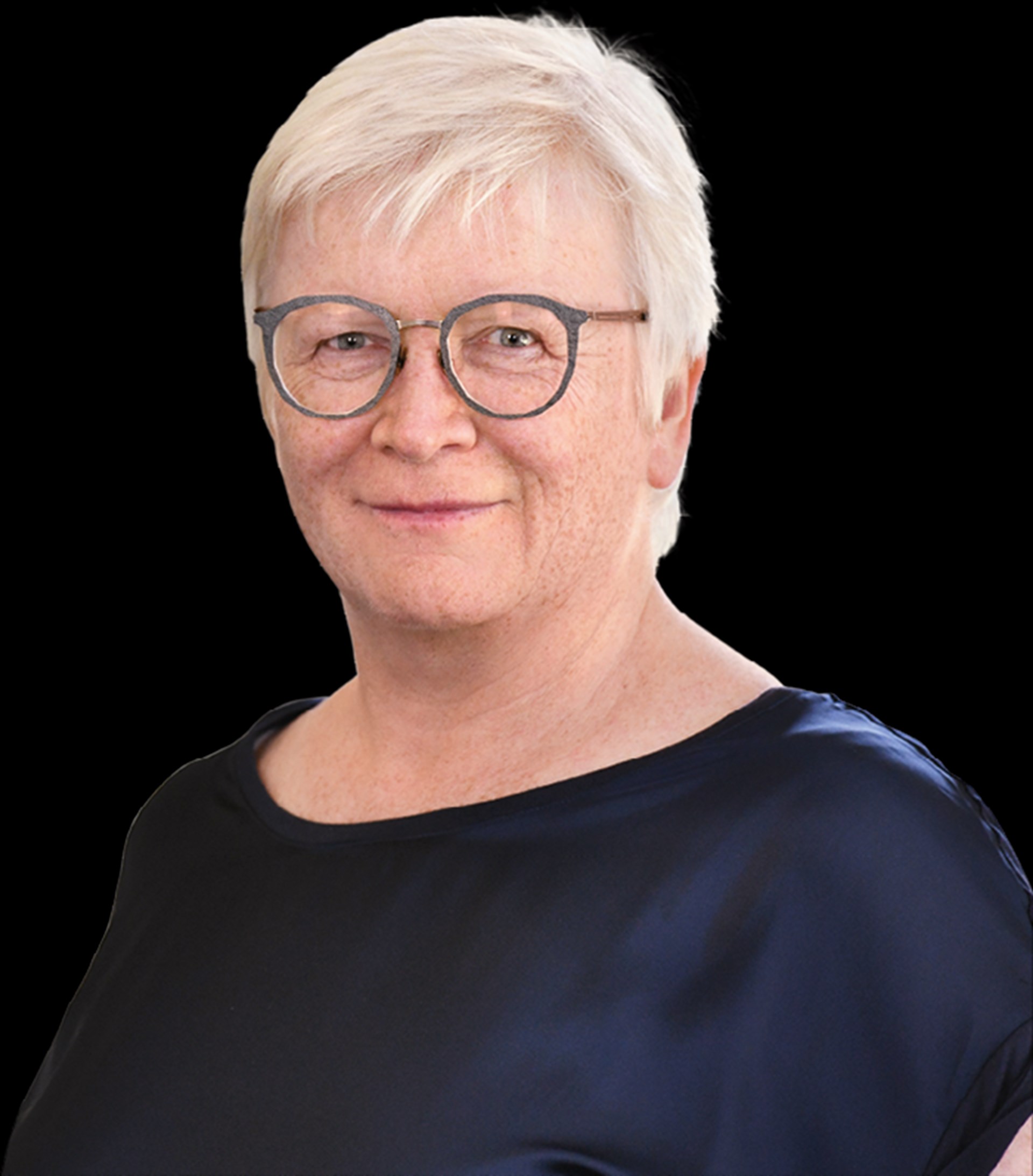 Lächelnde Frau mit weißen Haaren und Brille, die ein dunkelblaues Shirt trägt
