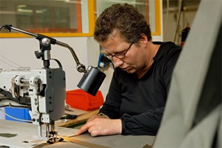 Ein Mann bei der Arbeit in einer Nähwerkstatt einer Werkstatt für Menschen mit Behinderung