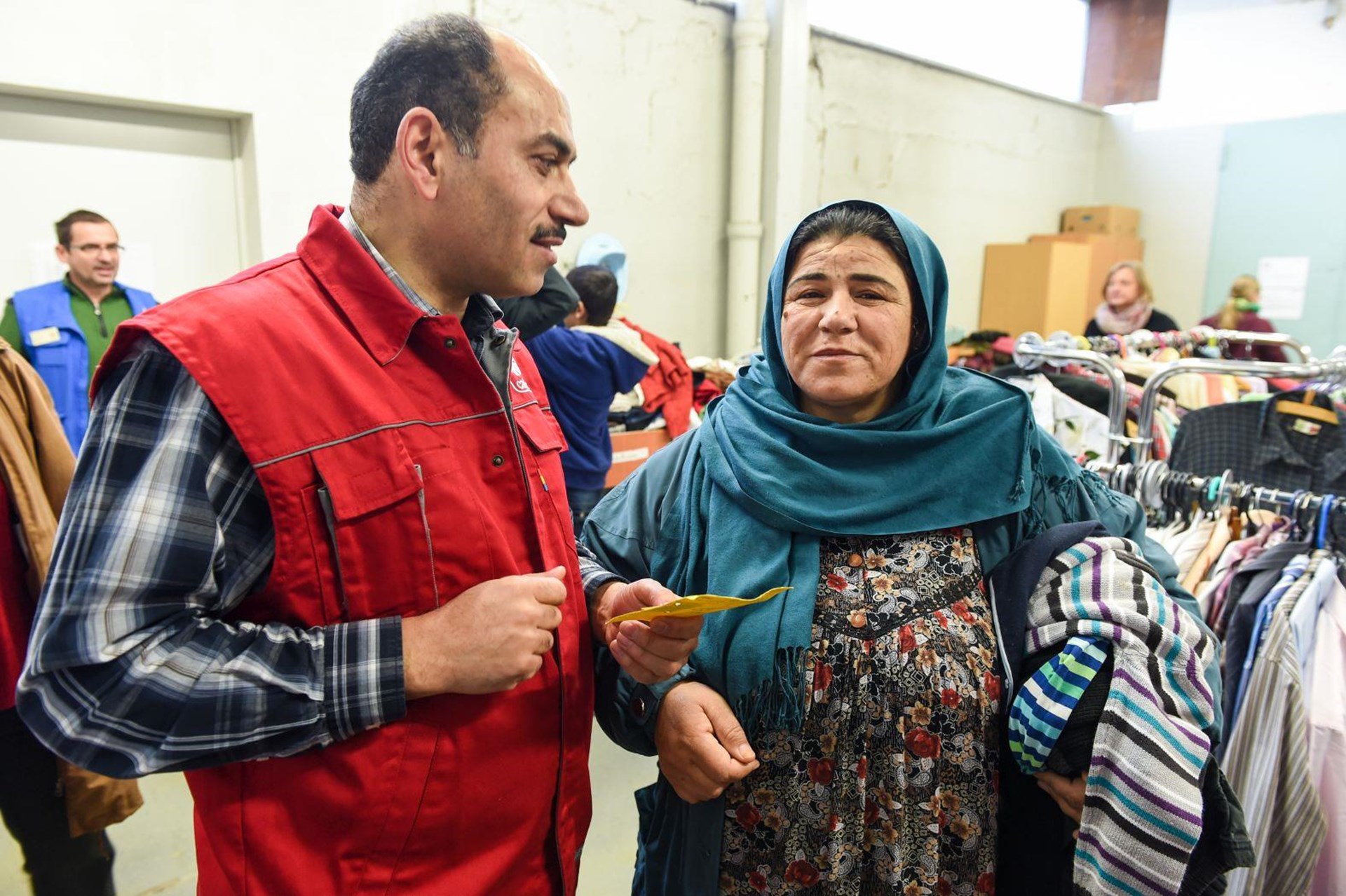 Flüchtlingshelfer spricht mit Frau im Flüchtlingsheim