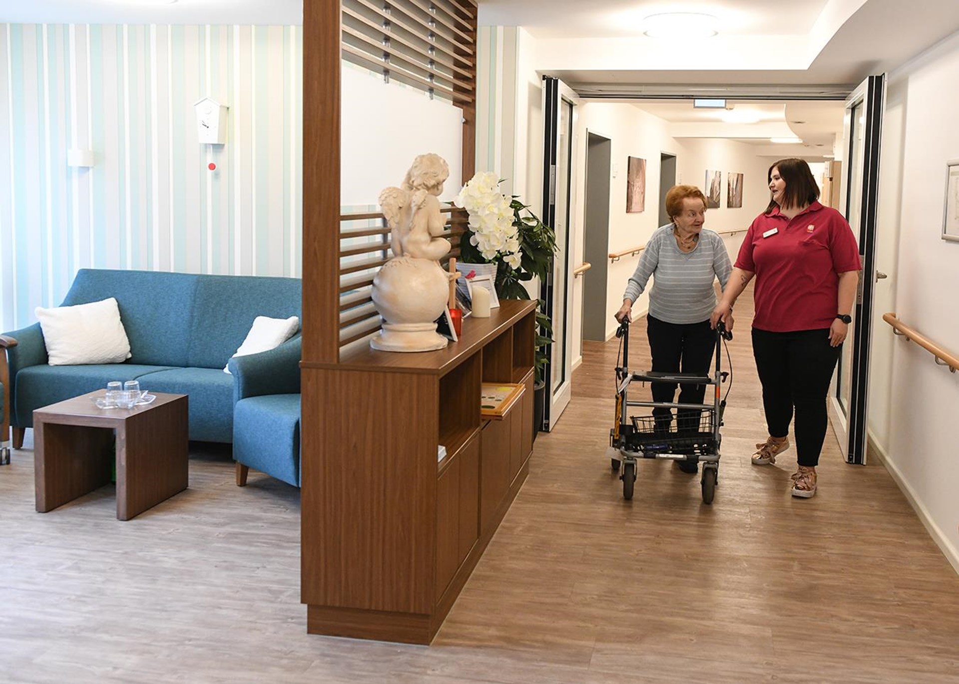 Seniorin mit Rollator und junger Pflegerin