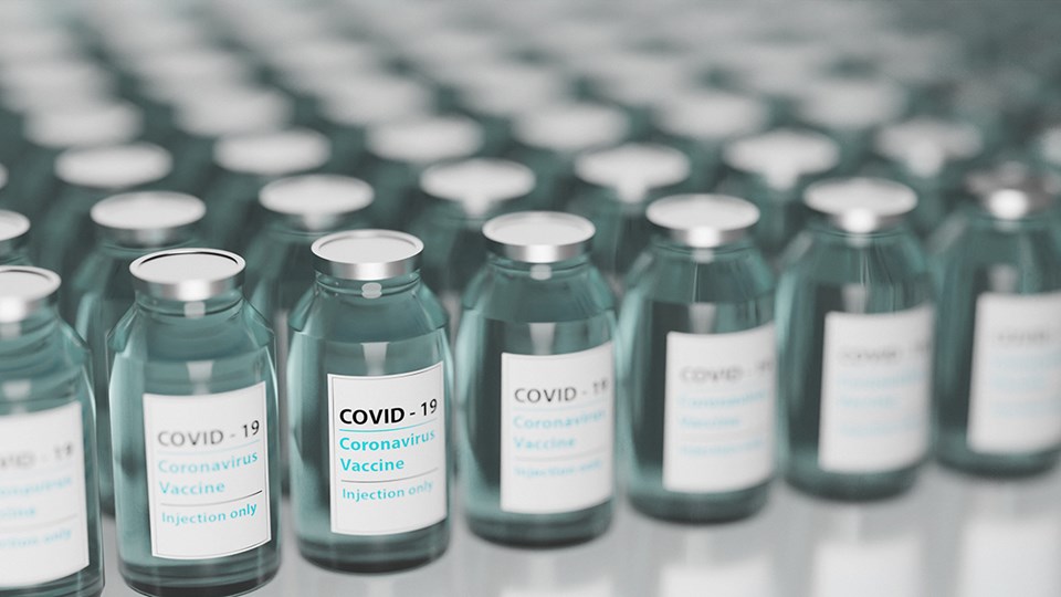 Fläschchen eines Covid-19-Impfstoffs, die nebeneinander aufgereiht sind