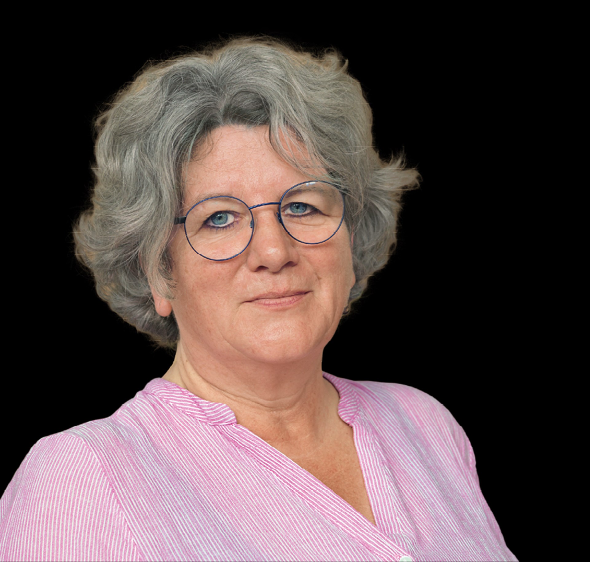 Lächelnde Frau mit grauen Haaren und Brille, die ein rosa Hemd trägt