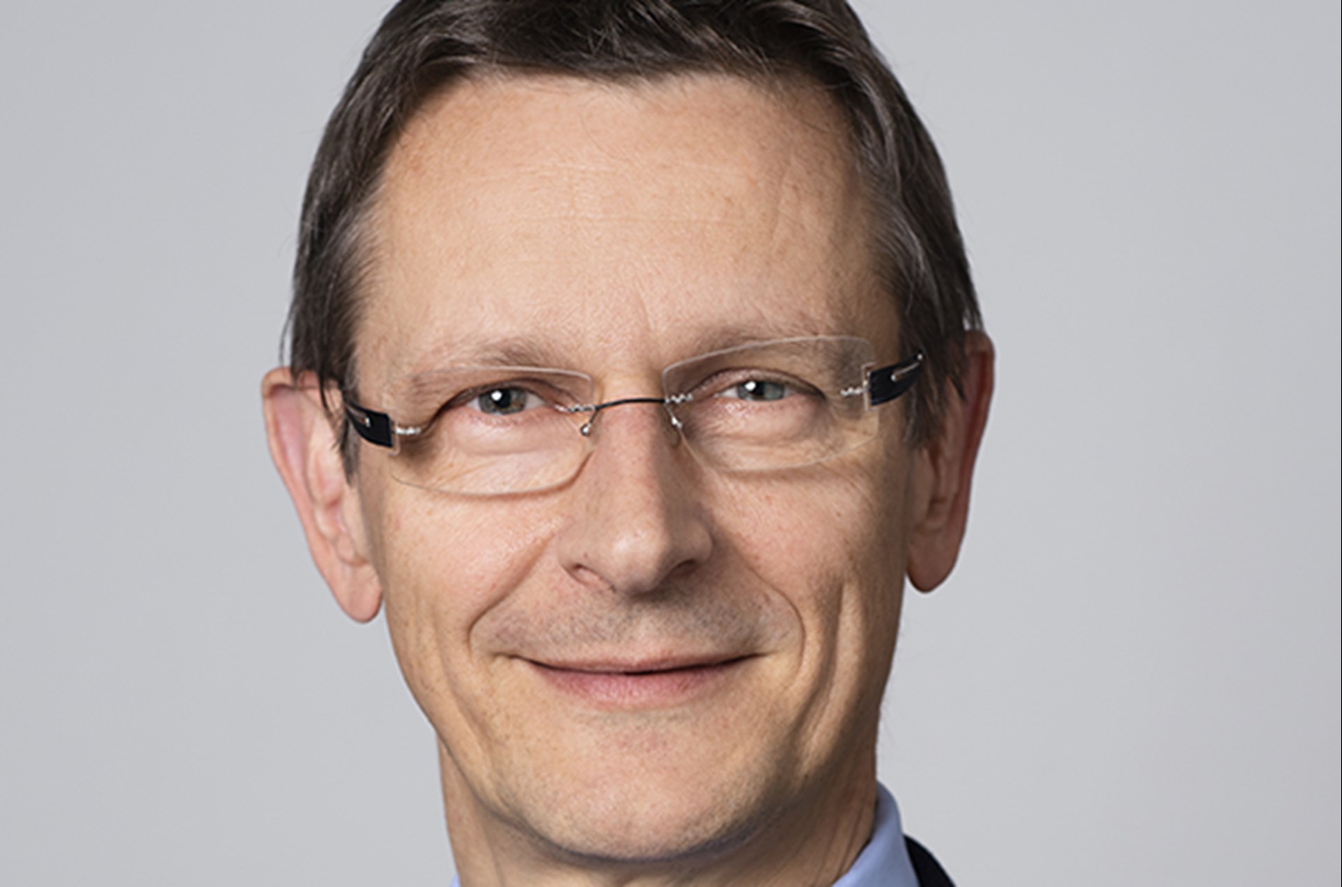 Lächelnder Mann mit braunen Haaren und Brille