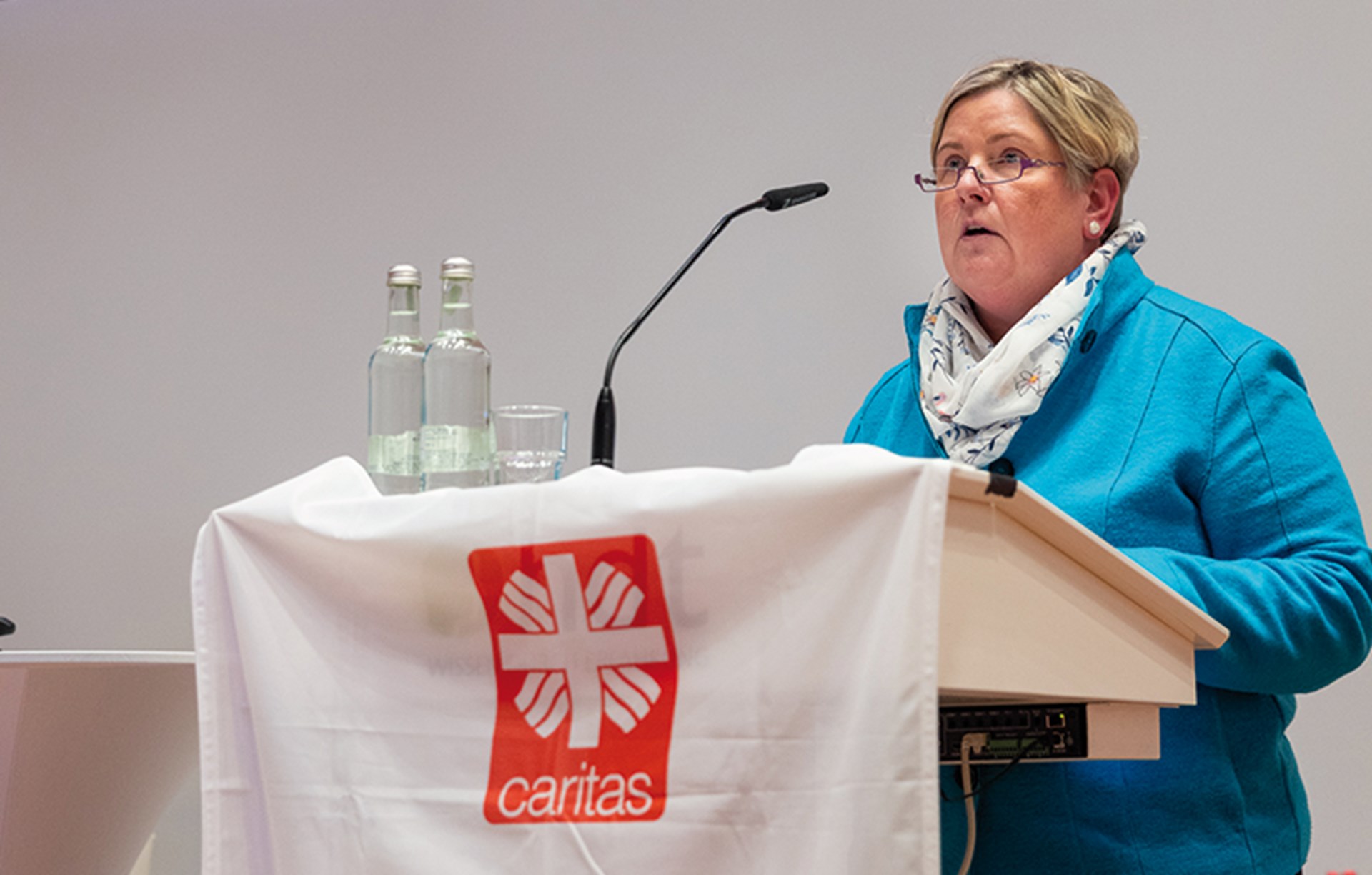 Eine Frau steht beim 2. Kath. Krankenhaustag in Essen an einem Pult und hält eine Rede