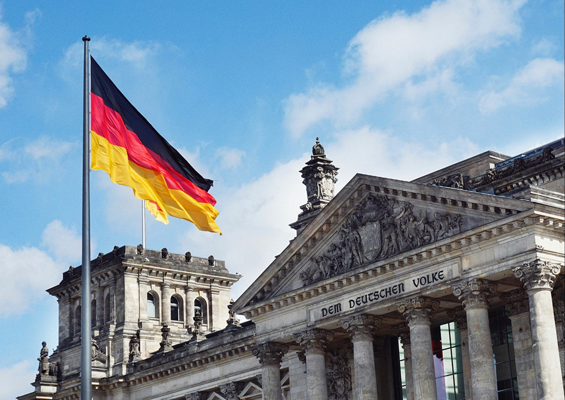 Das Reichstagsgebäude in Berlin mit einer wehenden Deutschland-Flagge