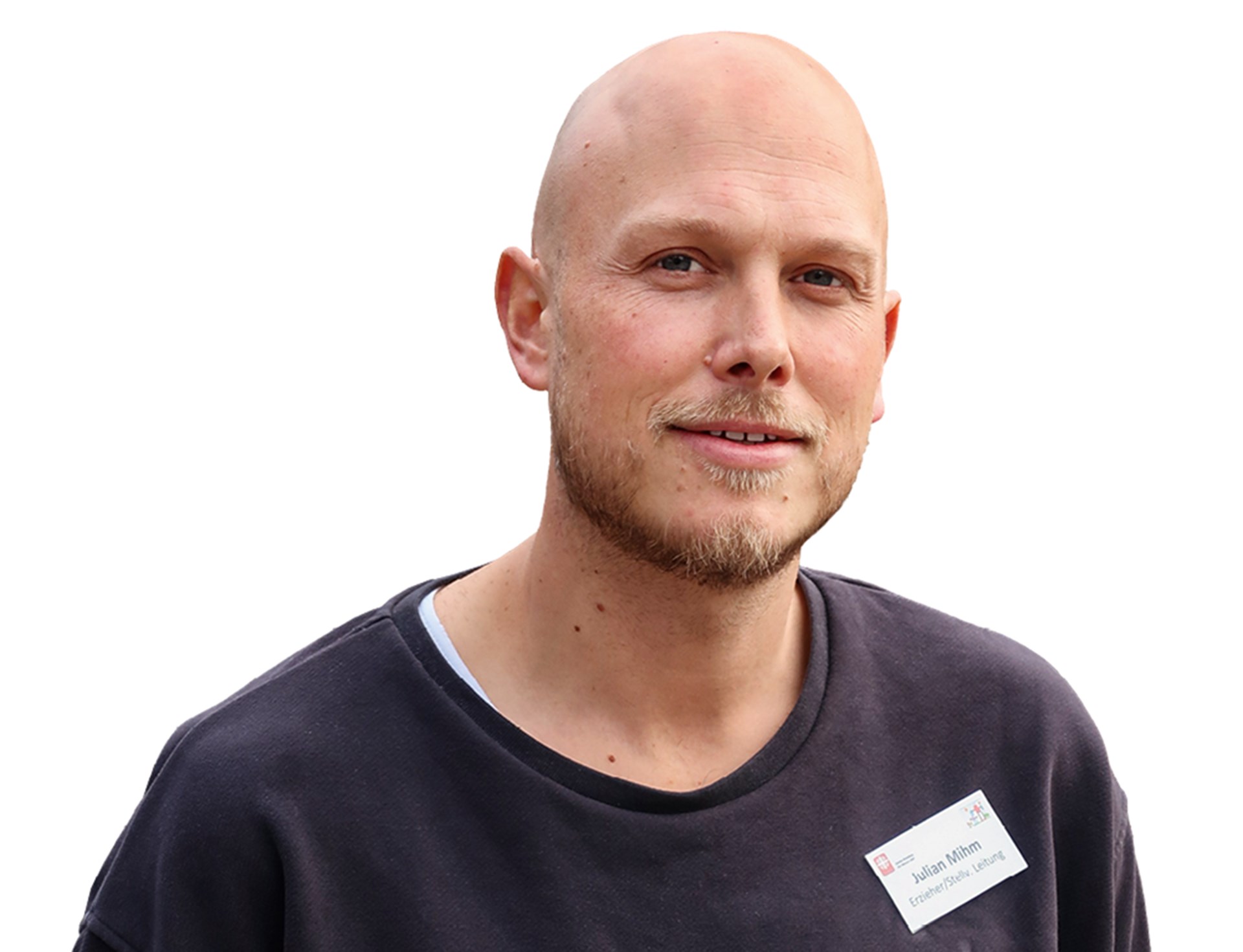 Lächelnder Mann mit Glatze und Bart, der einen dunkelblauen Pullover trägt