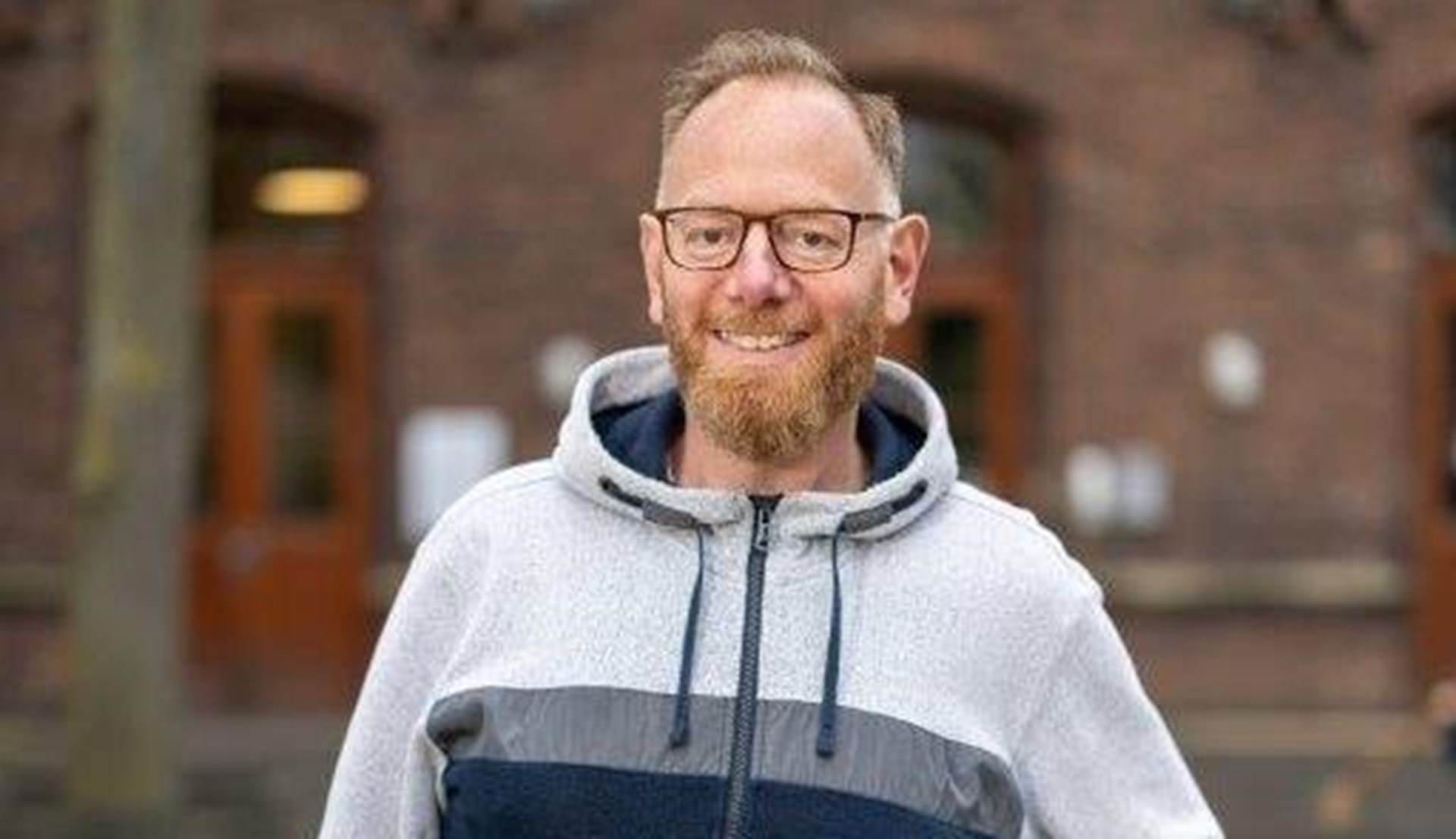 Schlanker Mann mit Bart auf einem Schulhof
